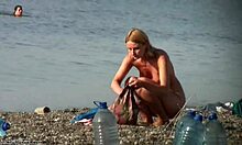 A blonde lady feeling the sand of the beach in high quality the video